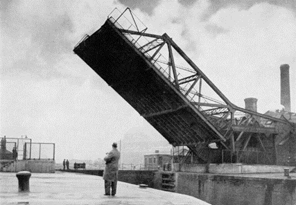 Rotherhithe Street, the view is looking south-west from the Thames. The chimneys in the background are the Rotherhithe Gas Works. Would this be the Surrey Lock bridge..png