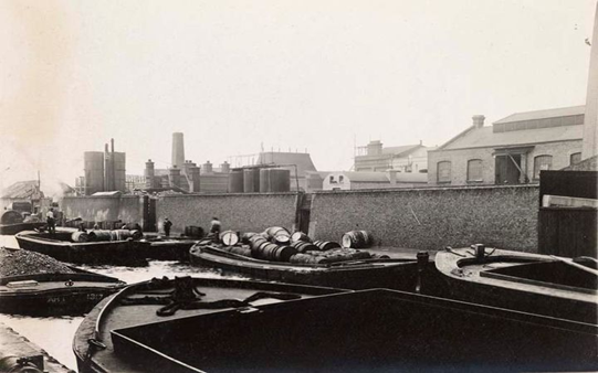 Surrey Canal, Dussek Brothers & Co. Ltd., Dussek Wharf. Lighters filled with barrels and loose coal sometime between 1915-1925.  X..png