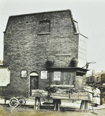 Albion Street, Rotherhithe, disused Oil and Colour Stores at the junction with Neptune Street, market stall with crates, leafy vegetables, celery, parsnips, c1905.   X..png