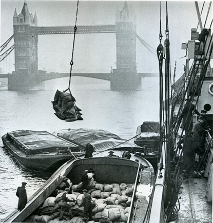 Pool of London, unloading cargo from a ship to a lighter c1920.   X..png