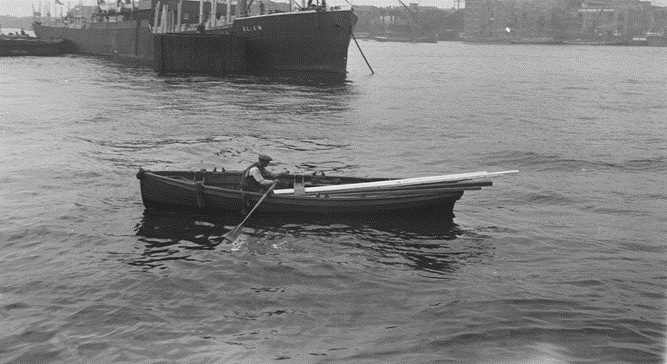 Surrey Docks, waterman salvaging timber near the Surrey entrance, c1933.  SS Ellen in the background.  X..png