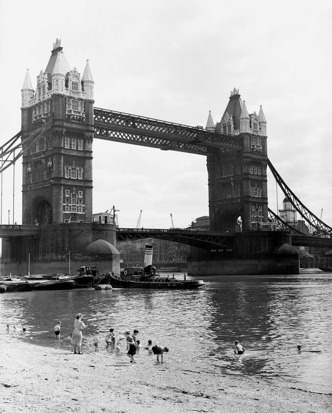Tower Bridge, paddling in the River Thames on a man-made beach with Tower Bridge in the background.1953.jpg
