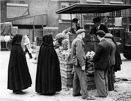 Borough Market near London Bridge c1920, cloaked nuns queuing for vegetables.  X.png