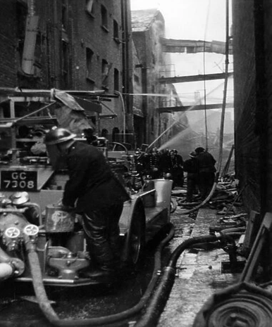 Bermondsey Wall--The Blitz 1944. Firefighters in action with fire engines and hosepipes at Chambers Wharf.  X..png