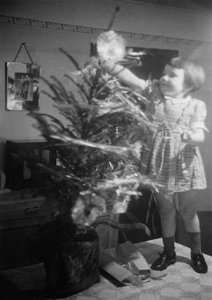Christmas Street, a little girl decorates a Christmas tree, December 1946. X..jpg