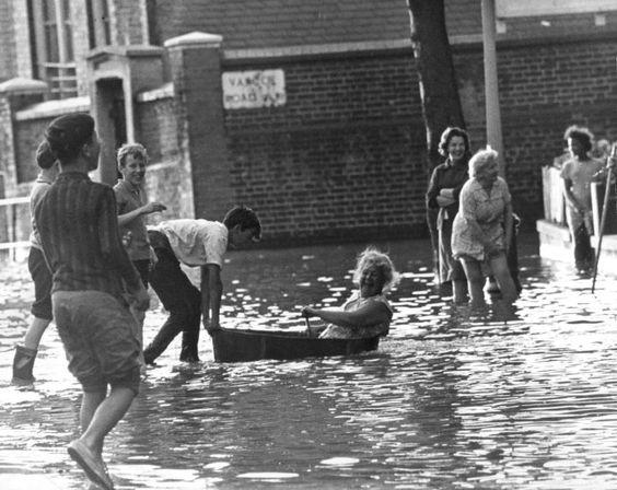 A resident paddle down her flooded street in a bath tub when a water main burst in South Bermondsey.jpg
