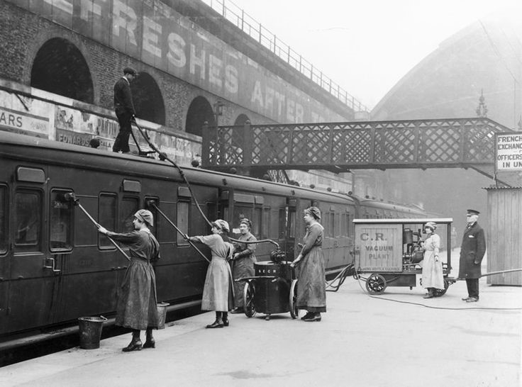 Women workers using an industrial vacuum cleaner to clean railway carriages at London Bridge Station..jpg