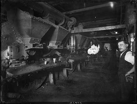 Guys Hospital. Hoppers filled with coal in a room, possibly the furnace room, with a man standing in the foreground 1920 -1939.  X.png
